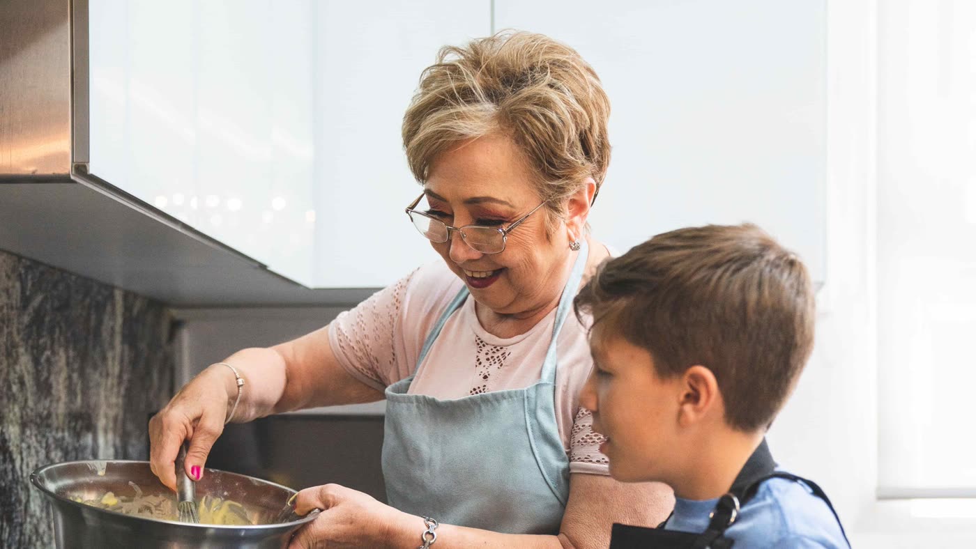 A grandmother and grandson cooking together in the kitchen